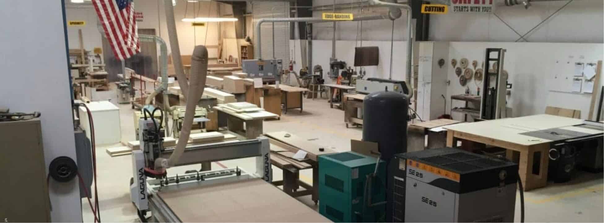 az-cabinet-maker-workshop-with-professional-woodworking-machinery Craftsman assembling wood cabinet pieces in the production workshop
