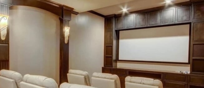custom-media-room-cabinetry-surrounding-a-home-theater-screen Custom media room cabinetry surrounding a home theater screen